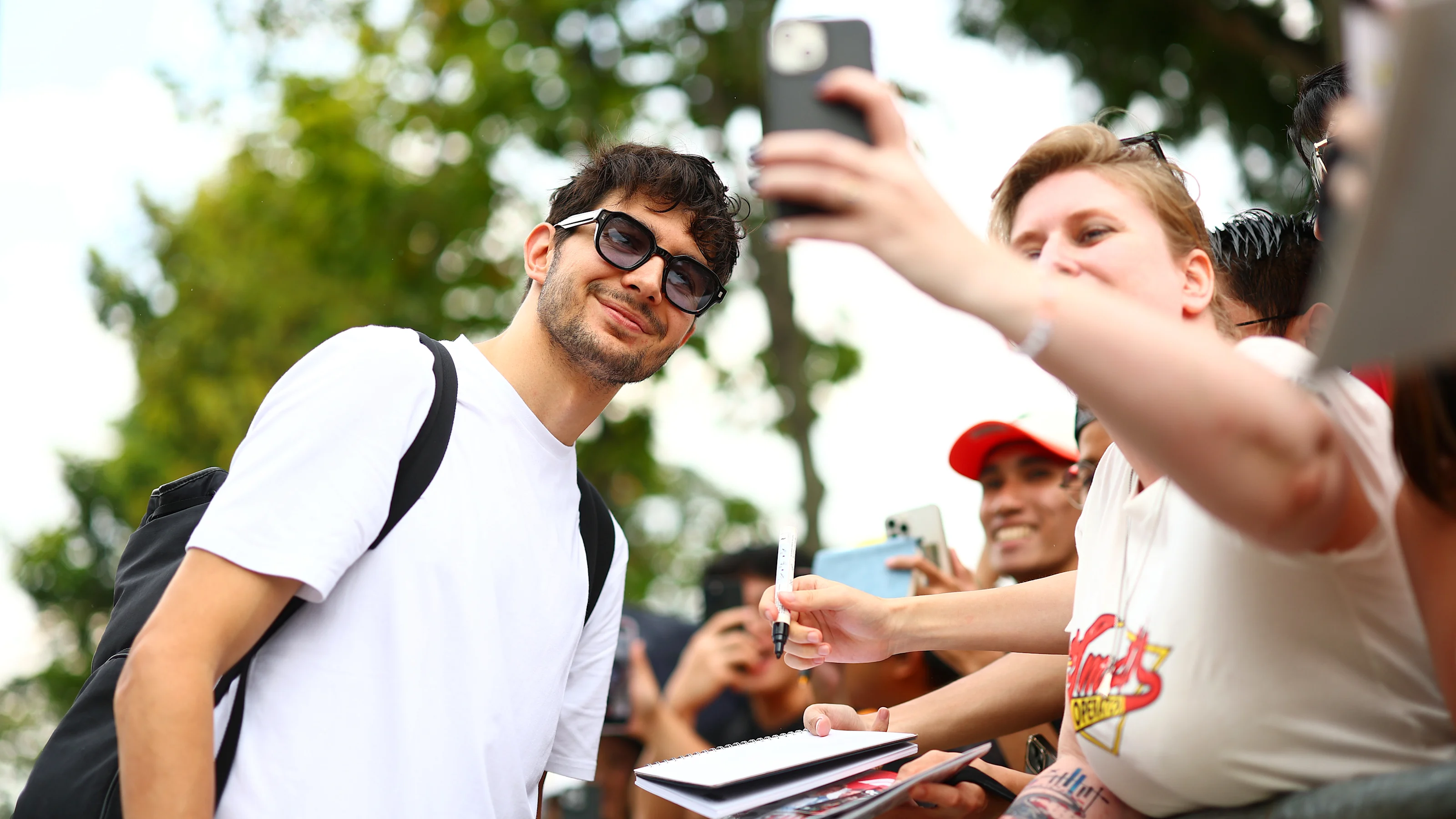 SINGAPORE, SINGAPORE - OCTOBER 02: Esteban Ocon of France and Haas F1 poses for a selfie with a fan