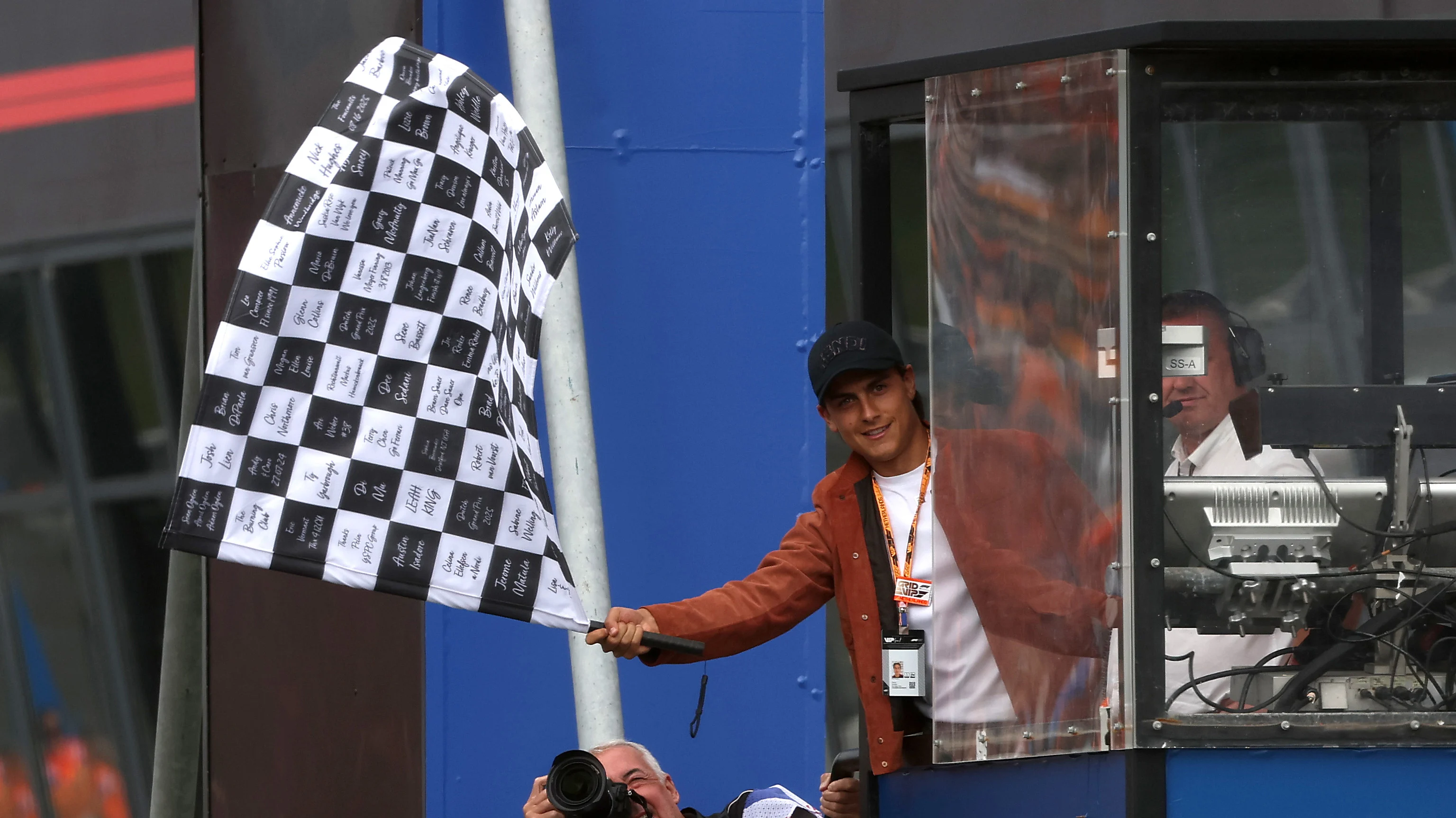 Argentine footballer and World Cup winner Paulo Dybala waves the chequered flag during the F1 Grand Prix of Netherlands. Swipe for more images