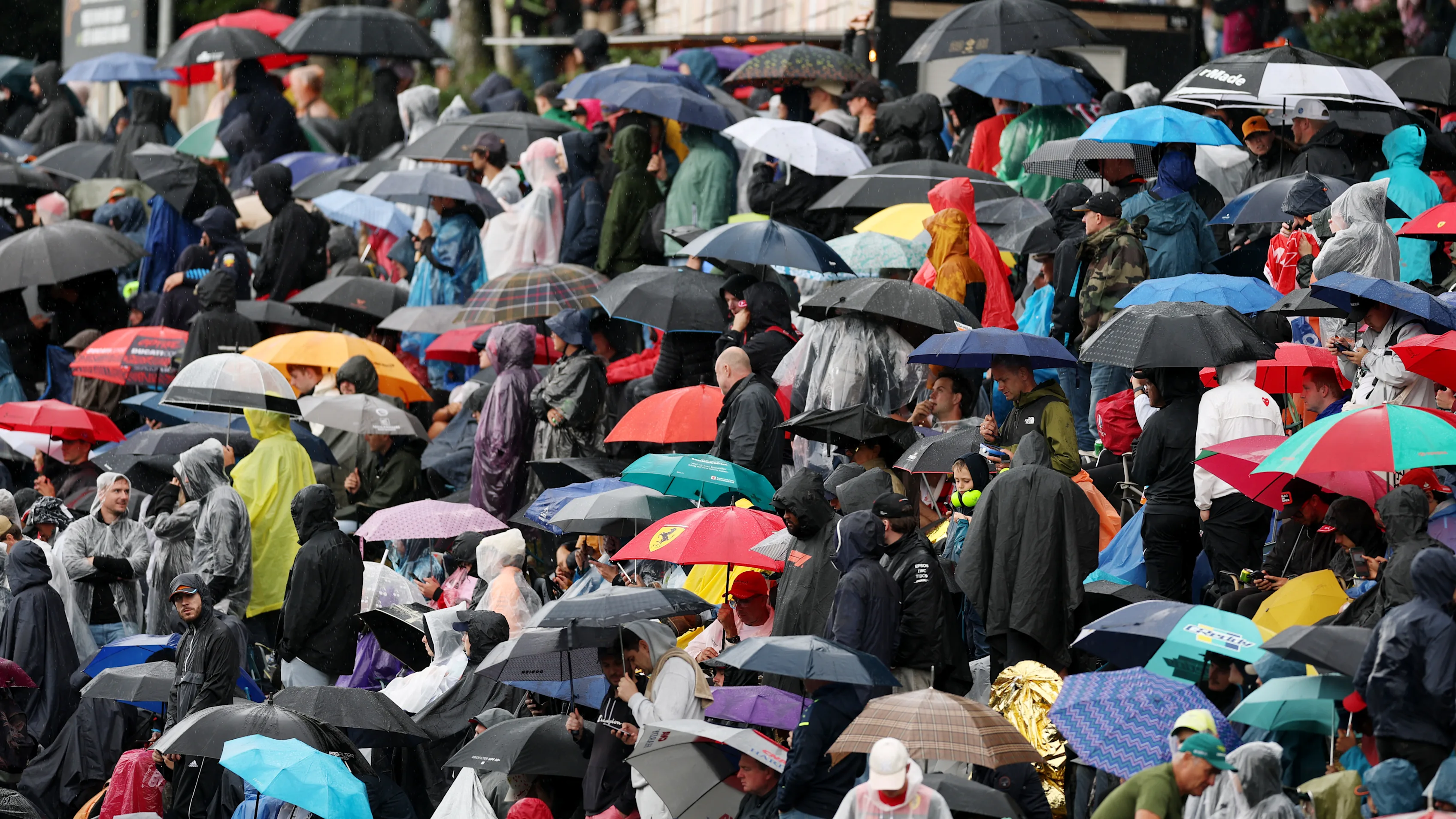 SPA, BELGIUM - JULY 27: Fans cover up from the rain with umbrellas during the F1 Grand Prix of