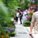 Fernando Alonso arrives at the paddock on Thursday in an Aston Martin branded polo