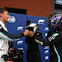 SPA, BELGIUM - AUGUST 28: Second place qualifier George Russell of Great Britain and Williams and third place qualifier Lewis Hamilton of Great Britain and Mercedes GP celebrate in parc ferme during qualifying ahead of the F1 Grand Prix of Belgium at Circuit de Spa-Francorchamps on August 28, 2021 in Spa, Belgium. (Photo by John Thys - Pool/Getty Images)