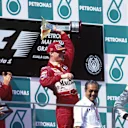 Winner Eddie Irvine celebrates as Schumacher(left) and Hakkinen watch
Malaysian GP, Sepang, 17 October 1999 © ©Sutton Motorsport Images