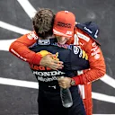 ABU DHABI, UNITED ARAB EMIRATES - DECEMBER 12: Race winner and 2021 F1 World Drivers Champion Max Verstappen of Netherlands and Red Bull Racing is congratulated by Carlos Sainz of Spain and Ferrari in parc ferme during the F1 Grand Prix of Abu Dhabi at Yas Marina Circuit on December 12, 2021 in Abu Dhabi, United Arab Emirates. (Photo by Mahmoud Khaled - Formula 1/Formula 1 via Getty Images)