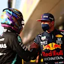 NORTHAMPTON, ENGLAND - JULY 16: Fastest qualifier Lewis Hamilton of Great Britain and Mercedes GP and second fastest qualifier Max Verstappen of Netherlands and Red Bull Racing shake hands in parc ferme during qualifying ahead of the F1 Grand Prix of Great Britain at Silverstone on July 16, 2021 in Northampton, England. (Photo by Dan Istitene - Formula 1/Formula 1 via Getty Images)