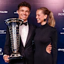 Norris and partner Magui Corceiro pose after the Briton collected his trophy