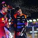 SINGAPORE, SINGAPORE - SEPTEMBER 17: Race winner Carlos Sainz of Spain and Ferrari celebrates with Second placed Lando Norris of Great Britain and McLaren and third placed Lewis Hamilton of Great Britain and Mercedes on the podium during the F1 Grand Prix of Singapore at Marina Bay Street Circuit on September 17, 2023 in Singapore, Singapore. (Photo by Dan Istitene - Formula 1/Formula 1 via Getty Images)