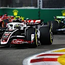 SINGAPORE, SINGAPORE - SEPTEMBER 22: Nico Hulkenberg of Germany driving the (27) Haas F1 VF-24 Ferrari leads Fernando Alonso of Spain driving the (14) Aston Martin AMR24 Mercedes on track during the F1 Grand Prix of Singapore at Marina Bay Street Circuit on September 22, 2024 in Singapore, Singapore. (Photo by Clive Rose - Formula 1/Formula 1 via Getty Images)