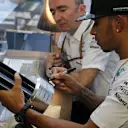 Mercedes' Lewis Hamilton, one of the judges in Tata Communications' inaugural F1 Connectivity Innovation Prize, adds his signature to the winners' trophy. © Tata Communications