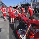 Ferrari's Kimi Raikkonen suffers a minor electronic problem and is led back to the garage by his mechanics © FOWC Ltd. No reproduction without permission.