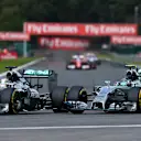 (L to R): Lewis Hamilton (GBR) Mercedes AMG F1 W05 and Nico Rosberg (GER) Mercedes AMG F1 W05 battle at Les Coombes on lap 2. Rosberg damaged his front wing and punctured the left rear wheel of Hamilton's car in the process. Formula One World Championship, Rd12, Belgian Grand Prix, Race Day, Spa-Francorchamps, Belgium, Sunday, 24 August 2014. © Sutton Images