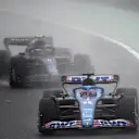 Alpine's Spanish driver Fernando Alonso (C) drives in front of Williams' Canadian driver Nicholas Latifi during the Formula One Japanese Grand Prix at Suzuka, Mie prefecture on October 9, 2022. (Photo by Toshifumi KITAMURA / AFP) (Photo by TOSHIFUMI KITAMURA/AFP via Getty Images)