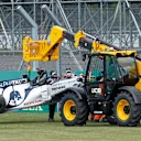 Marshals in face coverings take away the car of AlphaTauri's Russian driver Daniil Kvyat after a crash during the Formula One British Grand Prix at the Silverstone motor racing circuit in Silverstone, central England on August 2, 2020. (Photo by ANDREW BOYERS / POOL / AFP)