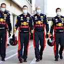 Red Bull mechanics and team personnel walk down the pitlane donning PPE