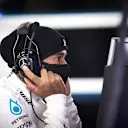 Lewis Hamilton wears a face mask as he looks over the data from his test on June 10