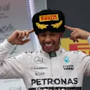 Race winner Lewis Hamilton wears a traditional Russian hat on the podium. © Sutton Motorsport Images