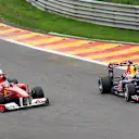 Mark Webber (right) completes a daring overtake on Fernando Alonso heading into Eau Rouge during the 2011 Belgian Grand Prix. © Sutton Motorsport Images
