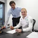 New Mercedes driver Valtteri Bottas signs his contract alongside Head of Mercedes-Benz motorsport Toto Wolff. © Daimler AG