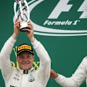 Race winner Lewis Hamilton (GBR) Mercedes AMG F1 celebrates with Valtteri Bottas (FIN) Mercedes AMG F1 on the podium with the trophy at Formula One World Championship, Rd10, British Grand Prix, Race, Silverstone, England, Sunday 16 July 2017. © Sutton Images