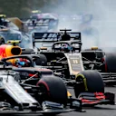 HUNGARORING, HUNGARY - AUGUST 04: Kimi Raikkonen, Alfa Romeo Racing C38, battles with Pierre Gasly, Red Bull Racing RB15, and Romain Grosjean, Haas VF-19, at the start during the Hungarian GP at Hungaroring on August 04, 2019 in Hungaroring, Hungary. (Photo by Steven Tee / LAT Images)