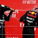 NORTHAMPTON, ENGLAND - AUGUST 09: Race winner Max Verstappen of Netherlands and Red Bull Racing and second placed Lewis Hamilton of Great Britain and Mercedes GP celebrate on the podium  during the F1 70th Anniversary Grand Prix at Silverstone on August 09, 2020 in Northampton, England. (Photo by Frank Augstein/Pool via Getty Images)