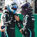 SPIELBERG, AUSTRIA - JULY 04: Pole position qualifier Valtteri Bottas of Finland and Mercedes GP shakes hands with second place qualifier and teammate Lewis Hamilton of Great Britain and Mercedes GP in parc ferme after qualifying for the Formula One Grand Prix of Austria at Red Bull Ring on July 04, 2020 in Spielberg, Austria. (Photo by Leonhard Foeger/Pool via Getty Images)