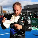 NUERBURG, GERMANY - OCTOBER 10: Pole position qualifier Valtteri Bottas of Finland and Mercedes GP removes his balaclava in parc ferme during qualifying ahead of the F1 Eifel Grand Prix at Nuerburgring on October 10, 2020 in Nuerburg, Germany. (Photo by Wolfgang Rattay - Pool/Getty Images)