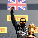 NORTHAMPTON, ENGLAND - AUGUST 02: Lewis Hamilton of Great Britain and Mercedes GP raises his fist as he celebrates on the podium after winning the Formula One Grand Prix of Hungary at Silverstone on August 02, 2020 in Northampton, England. (Photo by Dan Istitene - Formula 1/Formula 1 via Getty Images)