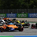 SPIELBERG, AUSTRIA - JULY 12:Carlos Sainz of Spain driving the (55) McLaren F1 Team MCL35 Renault and Valtteri Bottas of Finland driving the (77) Mercedes AMG Petronas F1 Team Mercedes W11 battle for position ahead of Alexander Albon of Thailand driving the (23) Aston Martin Red Bull Racing RB16 during the Formula One Grand Prix of Styria at Red Bull Ring on July 12, 2020 in Spielberg, Austria. (Photo by Clive Mason - Formula 1/Formula 1 via Getty Images)