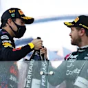 BAKU, AZERBAIJAN - JUNE 06: Race winner Sergio Perez of Mexico and Red Bull Racing and second placed Sebastian Vettel of Germany and Aston Martin F1 Team celebrate with sparkling wine on the podium during the F1 Grand Prix of Azerbaijan at Baku City Circuit on June 06, 2021 in Baku, Azerbaijan. (Photo by Clive Rose/Getty Images)