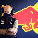Red Bull's design master Adrian Newey watches on from the garage