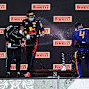 IMOLA, ITALY - APRIL 18: Second placed Lewis Hamilton of Great Britain and Mercedes GP, race winner Max Verstappen of Netherlands and Red Bull Racing and third placed Lando Norris of Great Britain and McLaren F1 celebrate with sparkling wine on the podium during the F1 Grand Prix of Emilia Romagna at Autodromo Enzo e Dino Ferrari on April 18, 2021 in Imola, Italy. (Photo by Lars Baron/Getty Images)