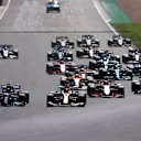 NORTHAMPTON, ENGLAND - JULY 18: Lewis Hamilton of Great Britain driving the (44) Mercedes AMG Petronas F1 Team Mercedes W12 and Max Verstappen of the Netherlands driving the (33) Red Bull Racing RB16B Honda lead the field into turn one at the start during the F1 Grand Prix of Great Britain at Silverstone on July 18, 2021 in Northampton, England. (Photo by Lars Baron/Getty Images)