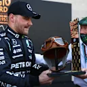 MEXICO CITY, MEXICO - NOVEMBER 06: Pole position qualifier Valtteri Bottas of Finland and Mercedes GP is presented with the Fangio Award to commemorate 70 years since Juan Manuel Fangio's first F1 World Drivers Championship win, by Sir Jackie Stewart in parc ferme during qualifying ahead of the F1 Grand Prix of Mexico at Autodromo Hermanos Rodriguez on November 06, 2021 in Mexico City, Mexico. (Photo by Bryn Lennon - Formula 1/Formula 1 via Getty Images)