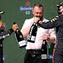 PORTIMAO, PORTUGAL - MAY 02: Race winner Lewis Hamilton of Great Britain and Mercedes GP, Mercedes GP engineer Kane Hemmant and Second placed Max Verstappen of Netherlands and Red Bull Racing  celebrate with Sparkling wine on the podium during the F1 Grand Prix of Portugal at Autodromo Internacional Do Algarve on May 02, 2021 in Portimao, Portugal. (Photo by Lars Baron/Getty Images)