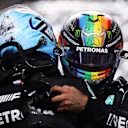 JEDDAH, SAUDI ARABIA - DECEMBER 04: Pole position qualifier Lewis Hamilton of Great Britain and Mercedes GP and second place qualifier Valtteri Bottas of Finland and Mercedes GP celebrate in parc ferme during qualifying ahead of the F1 Grand Prix of Saudi Arabia at Jeddah Corniche Circuit on December 04, 2021 in Jeddah, Saudi Arabia. (Photo by Lars Baron/Getty Images)