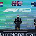 BARCELONA, SPAIN - MAY 09: Second placed Max Verstappen of Netherlands and Red Bull Racing, race winner Lewis Hamilton of Great Britain and Mercedes GP and third placed Valtteri Bottas of Finland and Mercedes GP stand on the podium during the F1 Grand Prix of Spain at Circuit de Barcelona-Catalunya on May 09, 2021 in Barcelona, Spain. (Photo by Emilio Morenatti - Pool/Getty Images)