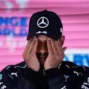 SPIELBERG, AUSTRIA - JUNE 26: Third place qualifier Lewis Hamilton of Great Britain and Mercedes GP wipes his face in parc ferme during qualifying ahead of the F1 Grand Prix of Styria at Red Bull Ring on June 26, 2021 in Spielberg, Austria. (Photo by Darko Vojinovic - Pool/Getty Images)