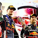 ABU DHABI, UNITED ARAB EMIRATES - NOVEMBER 20: Race Winner Max Verstappen of the Netherlands and Oracle Red Bull Racing and Third placed Sergio Perez of Mexico and Oracle Red Bull Racing celebrate on the podium during the F1 Grand Prix of Abu Dhabi at Yas Marina Circuit on November 20, 2022 in Abu Dhabi, United Arab Emirates. (Photo by Mark Thompson/Getty Images)