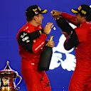 BAHRAIN, BAHRAIN - MARCH 20: Race winner Charles Leclerc of Monaco and Ferrari and Second placed Carlos Sainz of Spain and Ferrari celebrate on the podium during the F1 Grand Prix of Bahrain at Bahrain International Circuit on March 20, 2022 in Bahrain, Bahrain. (Photo by Lars Baron/Getty Images)