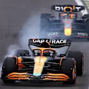 SAO PAULO, BRAZIL - NOVEMBER 11: Daniel Ricciardo of Australia driving the (3) McLaren MCL36 Mercedes locks a wheel under braking in front of Max Verstappen of the Netherlands driving the (1) Oracle Red Bull Racing RB18 during qualifying ahead of the F1 Grand Prix of Brazil at Autodromo Jose Carlos Pace on November 11, 2022 in Sao Paulo, Brazil. (Photo by Bryn Lennon - Formula 1/Formula 1 via Getty Images)