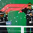 SAO PAULO, BRAZIL - NOVEMBER 13: Race winner George Russell of Great Britain and Mercedes and Second placed Lewis Hamilton of Great Britain and Mercedes celebrate on the podium during the F1 Grand Prix of Brazil at Autodromo Jose Carlos Pace on November 13, 2022 in Sao Paulo, Brazil. (Photo by Chris Graythen/Getty Images)