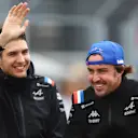 BUDAPEST, HUNGARY - JULY 31: Esteban Ocon of France and Alpine F1 waves as Fernando Alonso of Spain and Alpine F1 looks on from the drivers parade ahead of the F1 Grand Prix of Hungary at Hungaroring on July 31, 2022 in Budapest, Hungary. (Photo by Bryn Lennon - Formula 1/Formula 1 via Getty Images)
