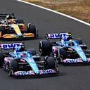BUDAPEST, HUNGARY - JULY 31: Fernando Alonso of Spain driving the (14) Alpine F1 A522 Renault, Esteban Ocon of France driving the (31) Alpine F1 A522 Renault and Daniel Ricciardo of Australia driving the (3) McLaren MCL36 Mercedes battle for track position during the F1 Grand Prix of Hungary at Hungaroring on July 31, 2022 in Budapest, Hungary. (Photo by Dan Istitene - Formula 1/Formula 1 via Getty Images)