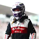 SUZUKA, JAPAN - OCTOBER 08: Fourteenth placed qualifier Zhou Guanyu of China and Alfa Romeo F1 walks in the Pitlane during qualifying ahead of the F1 Grand Prix of Japan at Suzuka International Racing Course on October 08, 2022 in Suzuka, Japan. (Photo by Dan Istitene - Formula 1/Formula 1 via Getty Images)