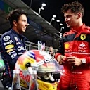 JEDDAH, SAUDI ARABIA - MARCH 26: Second placed qualifier Charles Leclerc of Monaco and Ferrari (R) talks to Pole position qualifier Sergio Perez of Mexico and Oracle Red Bull Racing (L) in parc ferme during qualifying ahead of the F1 Grand Prix of Saudi Arabia at the Jeddah Corniche Circuit on March 26, 2022 in Jeddah, Saudi Arabia. (Photo by Mark Thompson/Getty Images)