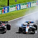 SUZUKA, JAPAN - SEPTEMBER 24: Logan Sargeant of United States driving the (2) Williams FW45 Mercedes locks a wheel under braking as he battles for track position with Valtteri Bottas of Finland driving the (77) Alfa Romeo F1 C43 Ferrari during the F1 Grand Prix of Japan at Suzuka International Racing Course on September 24, 2023 in Suzuka, Japan. (Photo by Clive Mason/Getty Images)