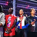 LAS VEGAS, NEVADA - NOVEMBER 18: Simone Ashley, Lupita Nyong'o, Liza Koshy, Kai Lenny and Kylie Minogue stand for the national anthem on the grid  prior to the F1 Grand Prix of Las Vegas at Las Vegas Strip Circuit on November 18, 2023 in Las Vegas, Nevada. (Photo by Dan Istitene - Formula 1/Formula 1 via Getty Images)
