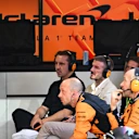 David Beckham and Gary Neville watch the action from the McLaren garage
