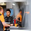 SUZUKA, JAPAN - SEPTEMBER 22: Lando Norris of Great Britain and McLaren talks with a McLaren team member in the garage during practice ahead of the F1 Grand Prix of Japan at Suzuka International Racing Course on September 22, 2023 in Suzuka, Japan. (Photo by Dan Istitene - Formula 1/Formula 1 via Getty Images)