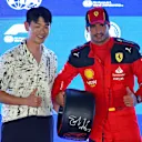 SINGAPORE, SINGAPORE - SEPTEMBER 16: Pole position qualifier Carlos Sainz of Spain and Ferrari is presented with the Pirelli Pole Position Award by Eric Nam in parc ferme during qualifying ahead of the F1 Grand Prix of Singapore at Marina Bay Street Circuit on September 16, 2023 in Singapore, Singapore. (Photo by Russell Batchelor/Getty Images)